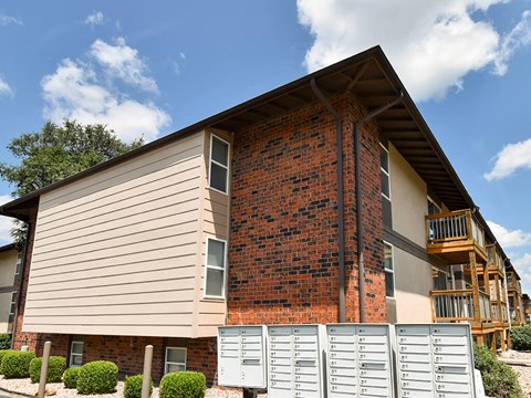 the front of a house with a brick wall and a staircase