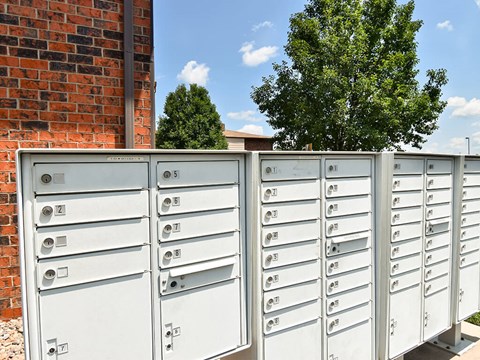 a bunch of mailboxes sitting on top of a fence