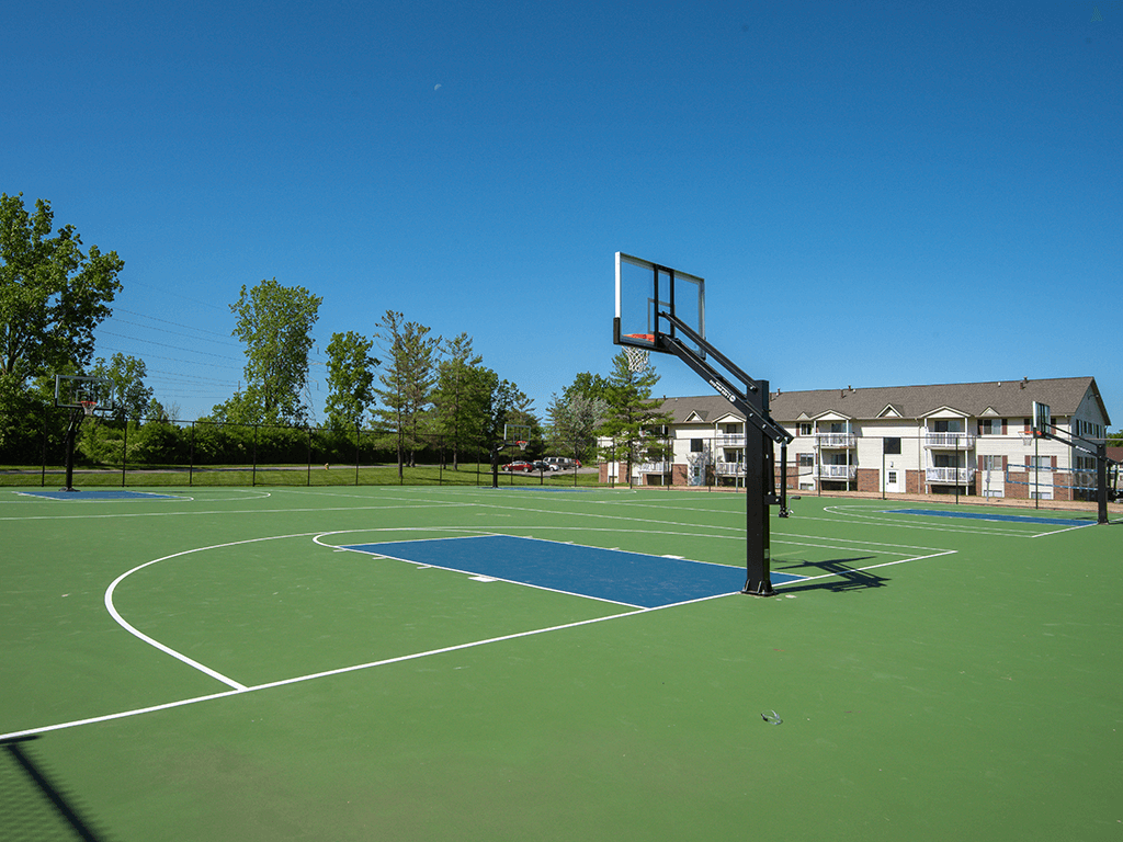 a basketball court with a house in the background