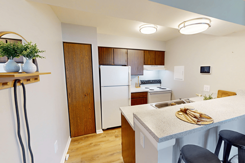 A kitchen with a white refrigerator and wooden cabinets.