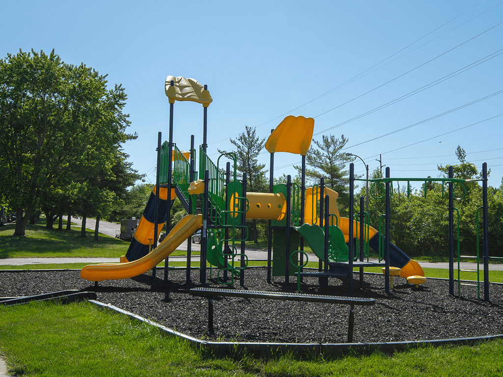 a playground with yellow and green equipment on a sunny day