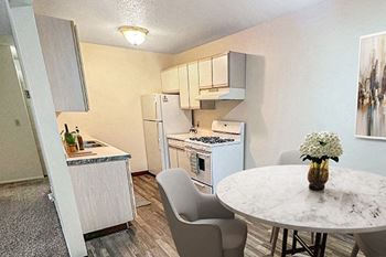 A kitchen with a table and chairs.