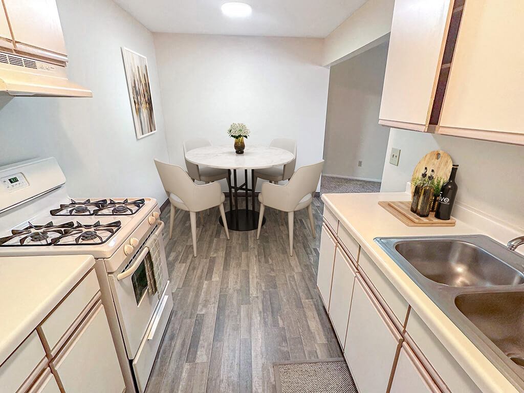 A kitchen with a table and chairs in the middle.