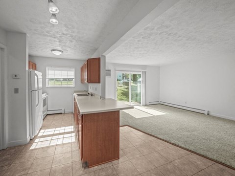 A kitchen with a refrigerator, sink, and cabinets.