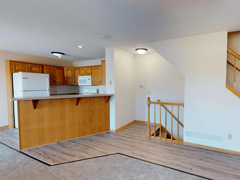 A kitchen with wooden cabinets and a white refrigerator.
