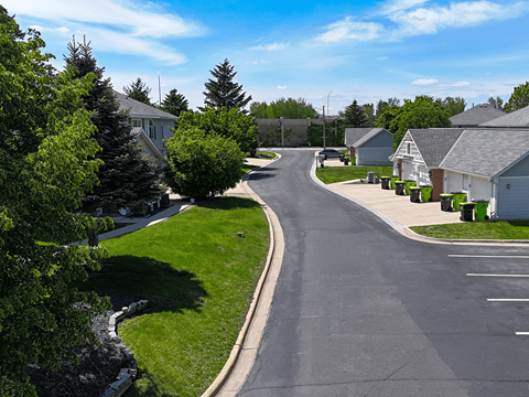 A residential street with houses on both sides and a clear blue sky.
