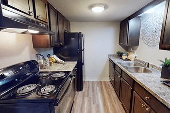 A kitchen with a black stove top oven and black fridge.