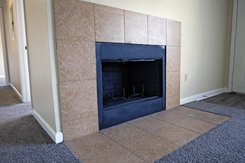 A fireplace with a blue hearth in a room with tan walls.