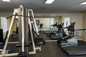A gym with treadmills, weight machines, and exercise equipment.