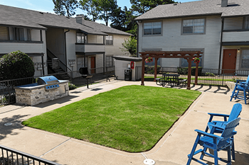 A small grassy area with a bench and a gazebo.