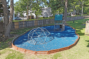 A small children's play area with a blue rubber surface and a swing set.