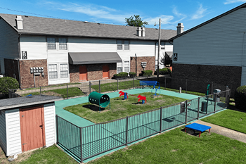 A playground with a green surface and a red slide.