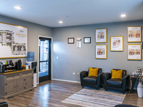 A living room with a couch, a coffee table, and pictures on the wall.
