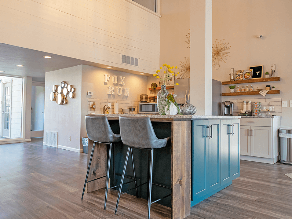 a kitchen with blue cabinets and a bar with two stools