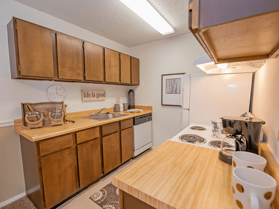 a kitchen with wooden cabinets and a white stove top oven