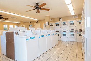 a large laundry room with washers and dryers