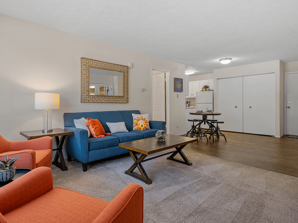 a living room with a blue couch and orange chairs