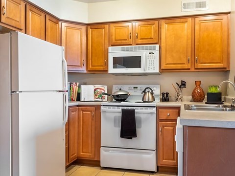 A kitchen with wooden cabinets and white appliances.