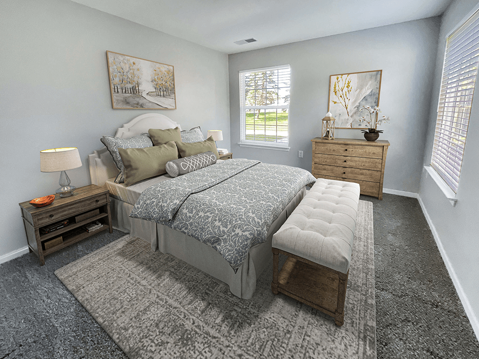 a bedroom with a bed and two dressers and a window