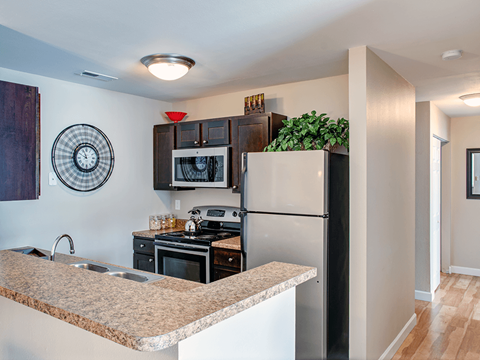 a kitchen with a granite counter top and a stainless steel refrigerator