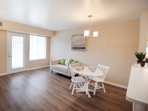 A dining room with a white table and chairs.