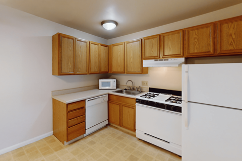 A kitchen with wooden cabinets and white appliances.
