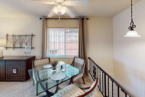 A dining room with a glass table and chairs.