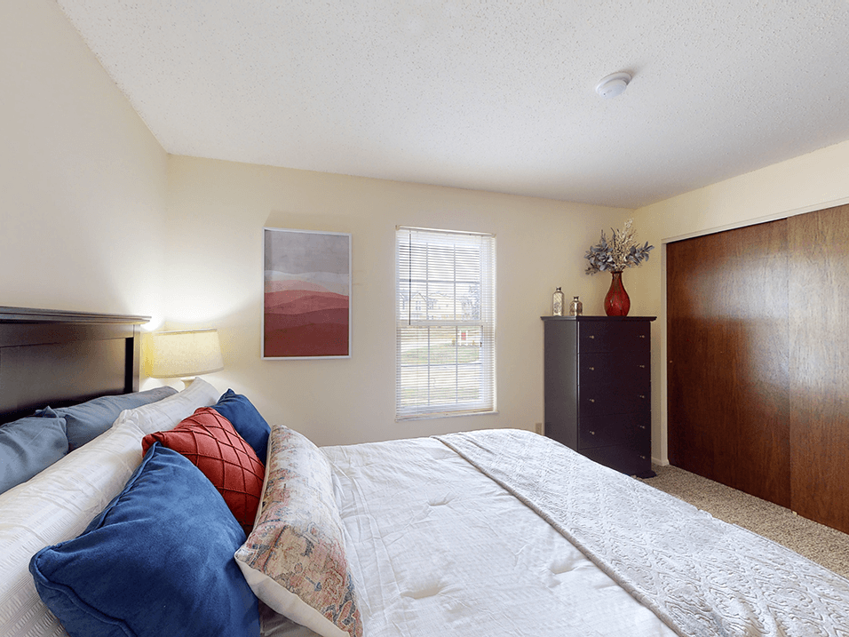 apartment bedroom with a large bed and a dresser