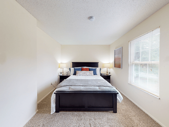 a bedroom with a bed and two nightstands