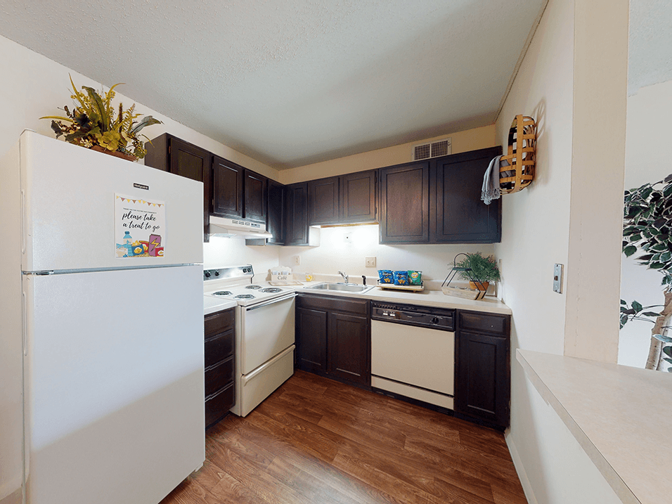 a kitchen with white appliances and dark wood cabinets