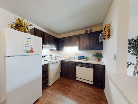 a kitchen with white appliances and dark cabinets