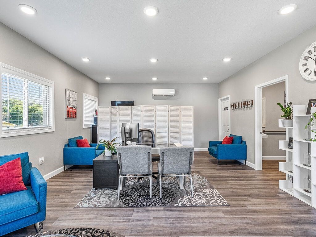 a living room and dining room with a table and chairs