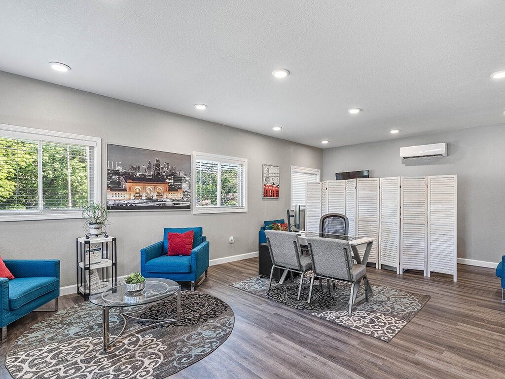 a living room and dining room with a table and chairs