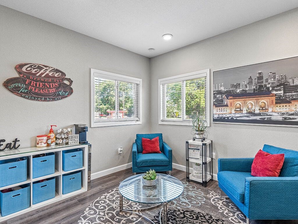 a clubhouse area with two blue chairs and a table