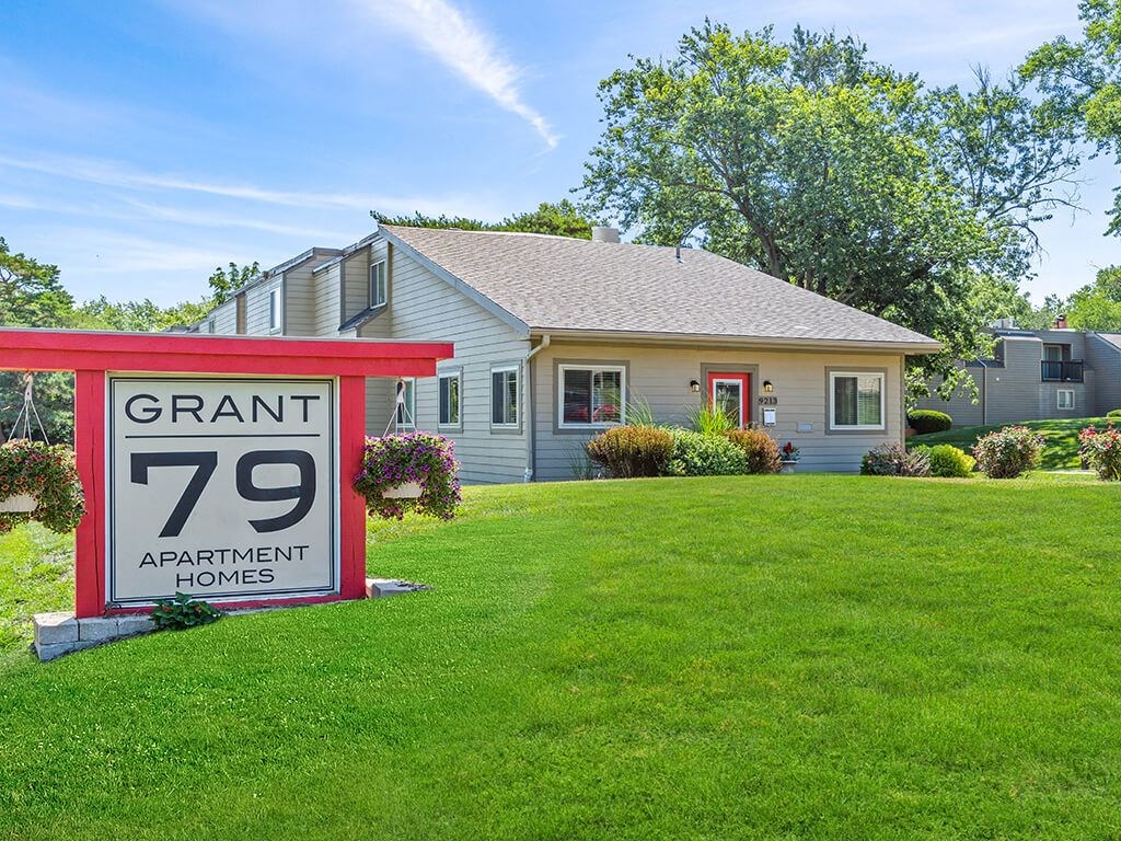 a apartment sign for Grant 79 in front of a leasing office