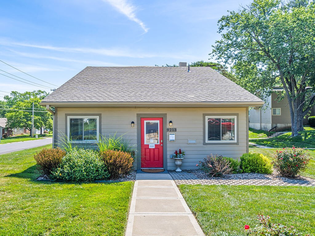 the front of a small house with a red door
