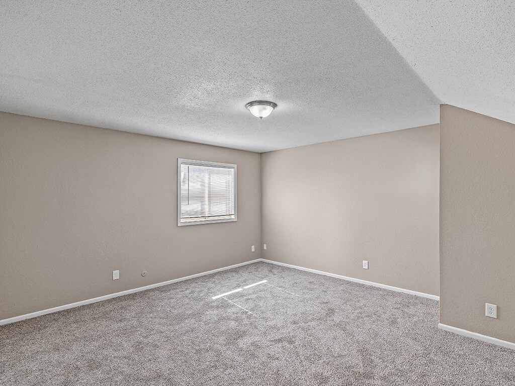 an empty room with carpet and a window