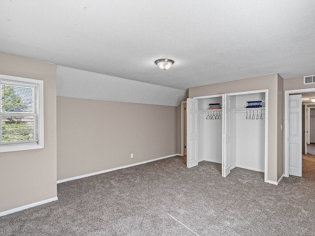 an empty room with a closet and a window