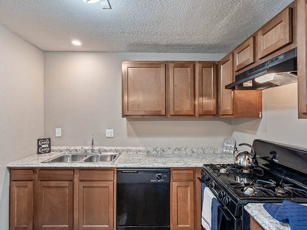 a kitchen with a stove top oven and a sink