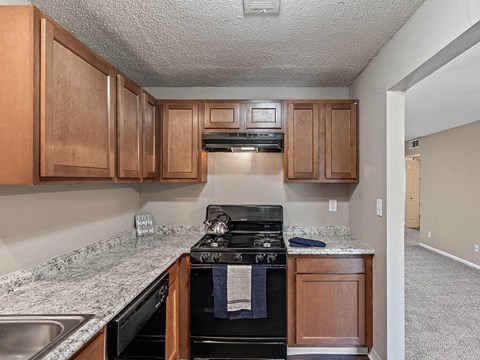 a kitchen with wood cabinets and a black stove