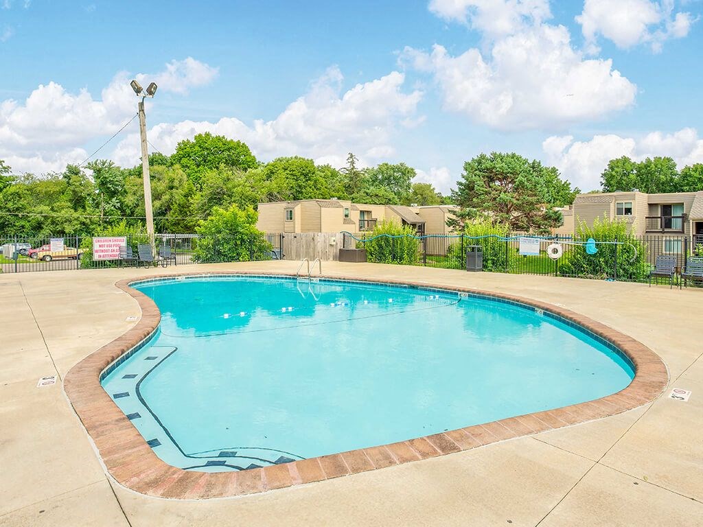 a resort style pool with trees and buildings in the background