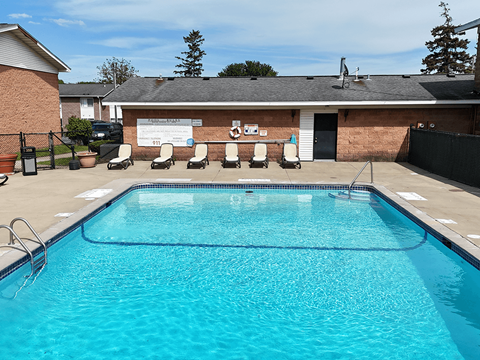 A swimming pool in front of a building with a white signboard.