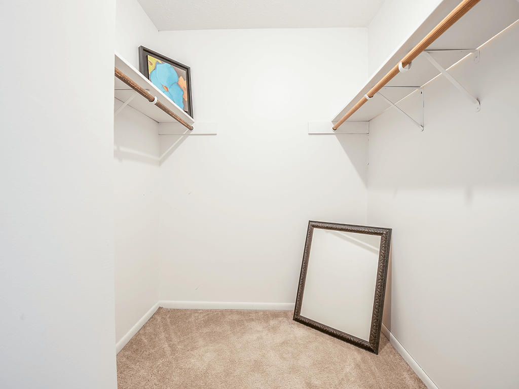 a room with a mirror and a white wall with a shelf and a mirror