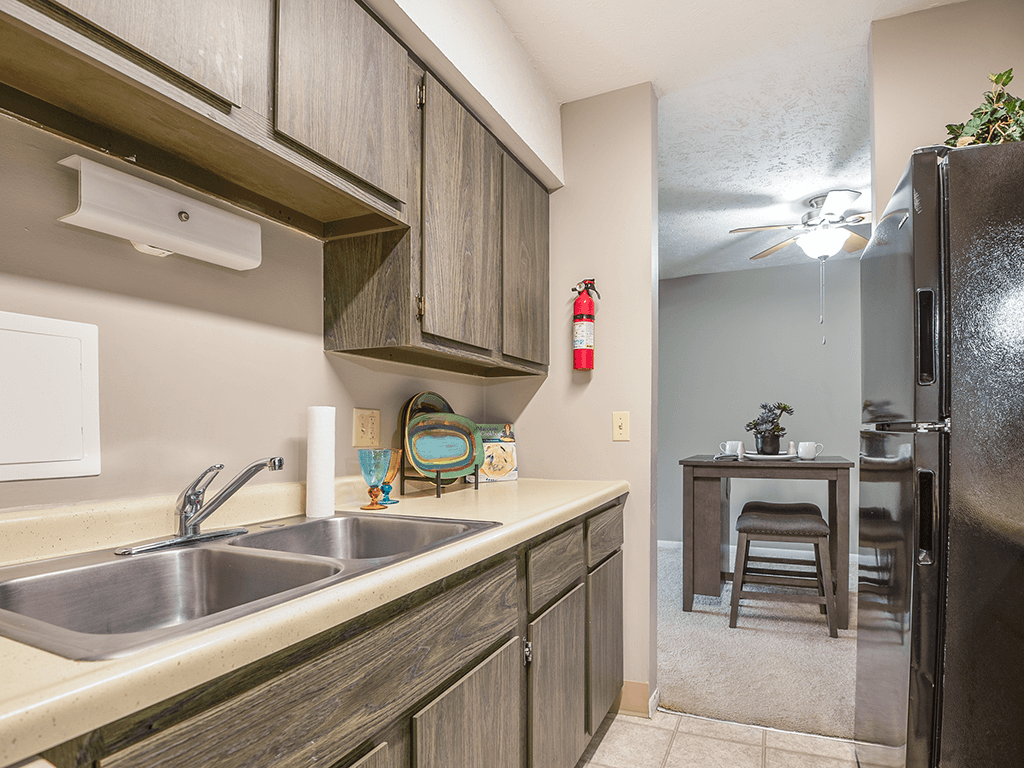 a kitchen with a sink and a refrigerator and a table with a chair