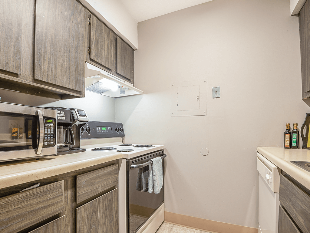 a kitchen with a stove and microwave and wooden cabinets
