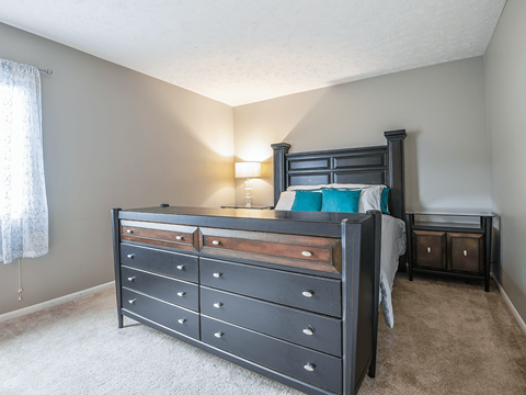 a bedroom with a bed and a dresser