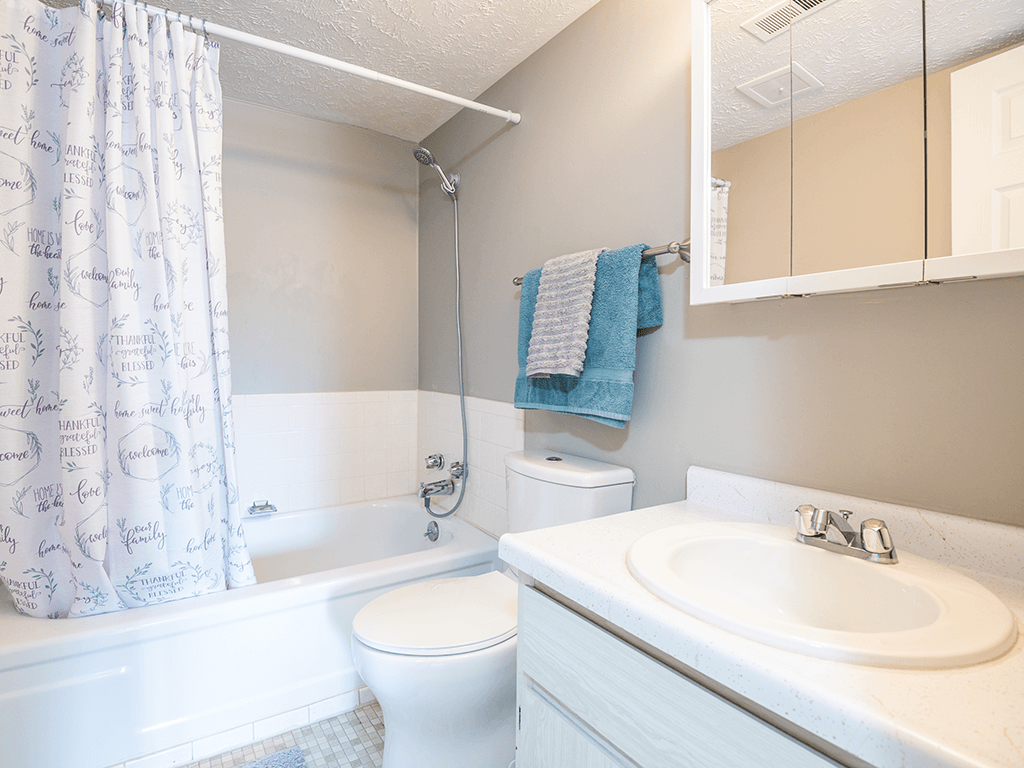 a bathroom with a sink toilet and bath tub and a shower curtain