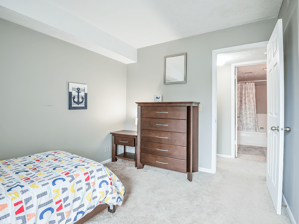 a bedroom with a bed and a dresser