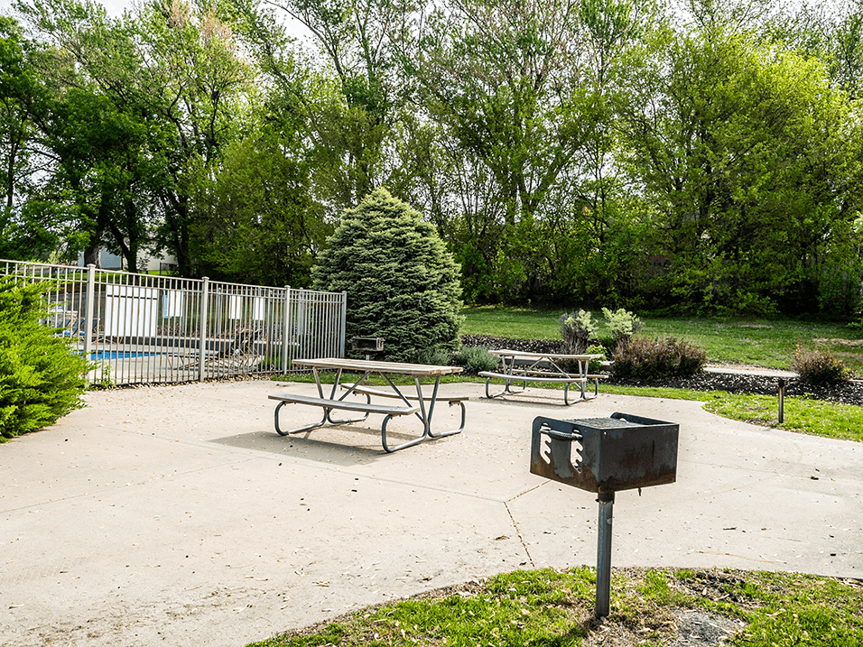 a picnic table with a grill on apartment property