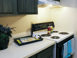 apartment kitchen with a white stove top oven next to a white counter top
